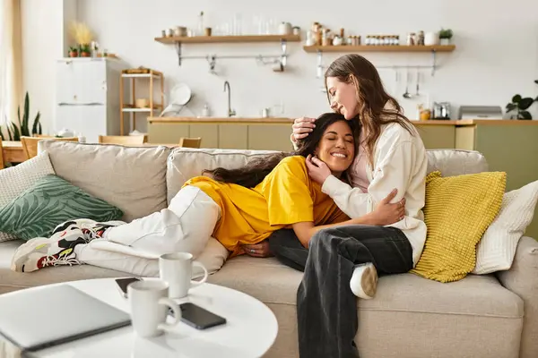 Sevgi dolu bir lezbiyen çift eve hoş geldin diyerek kanepede sarılır..