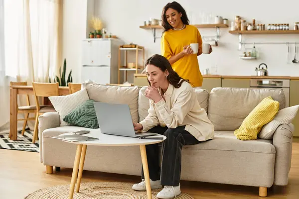 İki kadın güzel evlerinde sıcak bir anı paylaşırken, biri içkinin tadını çıkarıyor ve diğeri gülümsüyor..