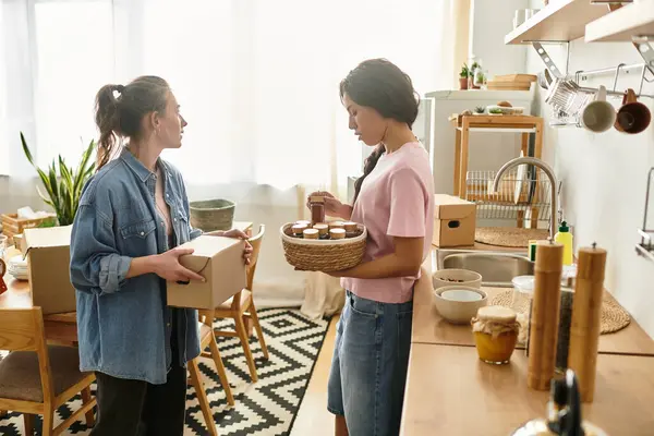 İki kadın, kutuları açarken ve evlerini düzenlerken hassas anlarını paylaşıyorlar..