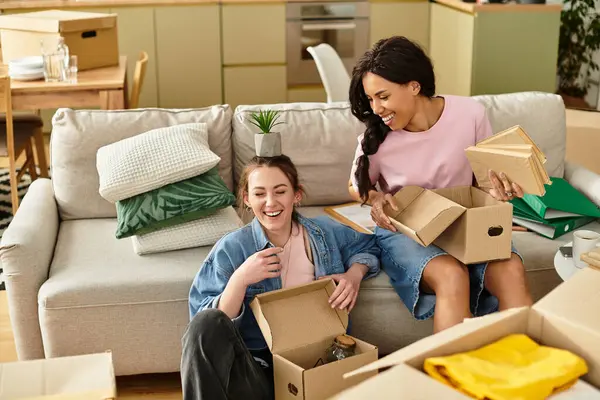 İki kadın yeni evlerinde bavullarını açarken gülüp kaynaşırlar..