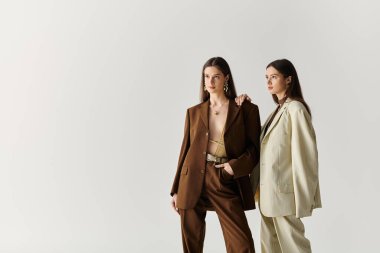 İki güzel ikiz kardeş şık kıyafetler giyer. Stüdyoda özgüven ve tarz yayarlar..