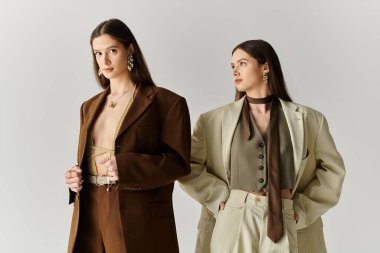 İkiz kardeşler benzersiz tarzlarını modern yaratıcı mekanlarda zarif giysiler içinde sergilerler..