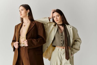 Genç ikiz kardeşler kişiliklerini şık kıyafetler ve kendine güvenen pozlarla ifade ederler..