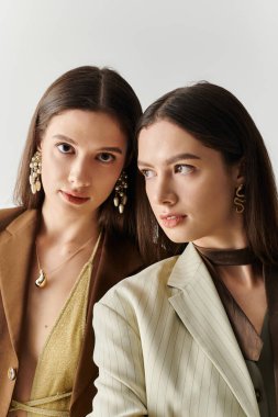 Güzel ikiz kardeşler moda kıyafetleriyle evde poz verirken aynı tarz ve zarafeti paylaşıyorlar..