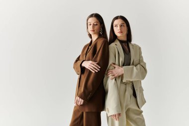 Şık ikiz kardeşler zarif bir şekilde poz verir, bireysel moda anlayışlarını ve güçlü bağlarını sergilerler..