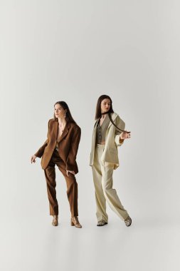 İki güzel ikiz kardeş kendilerine has tarzlarını tamamlayıcı giysiler içinde poz verirken sergilerler..
