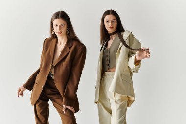 İkiz kardeşler stüdyoda kıyafetlerini koordine ederken özgüven ve zarafet gösterirler..