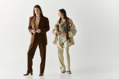 İki güzel ikiz kız kardeş moda ve karizma yayarak şık görünümlerini sergilerler..