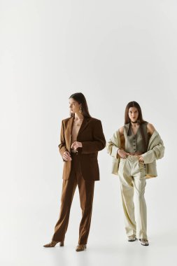 İkiz kardeşler şık kıyafetlerini temiz ve parlak bir mekanda gösterirken zarafet saçıyorlar..