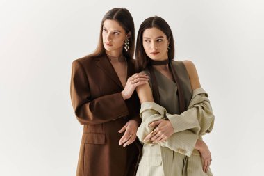 İkiz kız kardeşler şık kıyafetler içinde bağlarını sergilerler, güven ve tarz yayarlar..