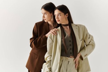 İkiz kardeşler birbirlerine nazik bir şekilde poz verirler, birbirlerine güven ve tarz yayarlar..