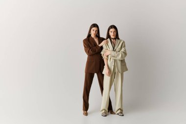 İkiz kardeşler güven ve tarz yayarlar, şık kıyafetler ve topuklularla birlikte poz verirler..