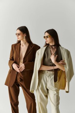 İkiz kardeşler şık giysilere ve şık aksesuarlara sahip şık mekânlarda modellik yaparken güven yayarlar..