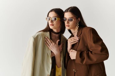 İkiz kardeşler şık kıyafetler giyip moda anlayışlarını ve bağlantılarını vurgularlar..