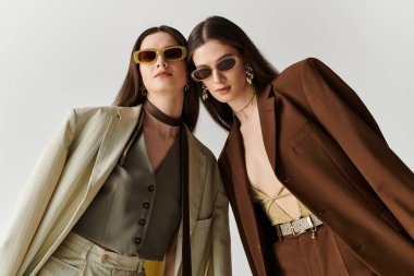 Güzel ikiz kardeşler moda kıyafetler ve aksesuarlar giyer, güven ve tarz yayarlar..