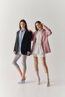 Çekici ikiz kardeşler şık kıyafetler sergiliyor. Birlikte durduklarında kendilerine güveni yayıyorlar..