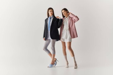 İki güzel ikiz kardeş şık kıyafetler giyer ve birlikte eğlenirler..