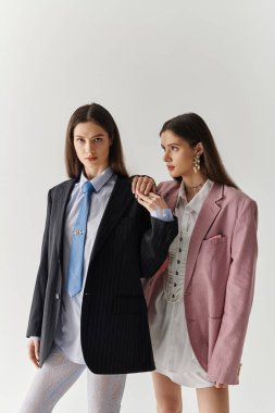 İki şık ikiz kardeş şık kıyafetler içinde benzersiz görünüşlerini sergiliyorlar..