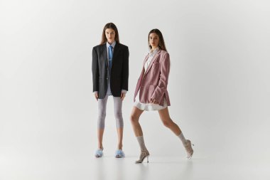 Moda ikizi kardeşler bir stüdyoda şık poz verirken cazibe ve yaratıcılık sergilerler..