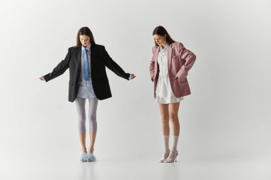 İkiz kardeşler kişiliklerini ve yaratıcılıklarını parlak bir mekanda şık kıyafetlerle ifade ederler..