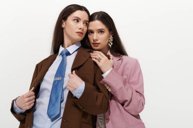 İkiz kardeşler, minimalist bir stüdyoda kaynaşırken bireysel tarzlarını güven içinde ifade ederler..