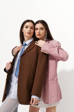 İki güzel ikiz kardeş birbirlerine uyum içinde sarılırken eşsiz tarzlarını sergilerler..