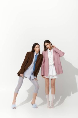 Moda ikizi kardeşler sanatsal pozlar vererek, onların farklı tarzlarını ve bağlarını vurgularlar..