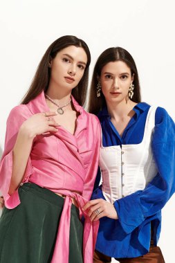 Güzel ikiz kardeşler benzersiz tarzlarını gösterirken şık bir ortamda kaynaşıyorlar..