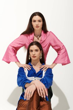 İki güzel ikiz kardeş benzersiz moda tarzlarını sergilerken birlikte kaliteli zaman geçirmenin keyfini çıkarıyorlar..