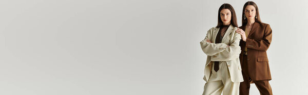 Две прекрасные сестры-близнецы стоят уверенно, подчеркивая свои уникальные стили и тесную связь.