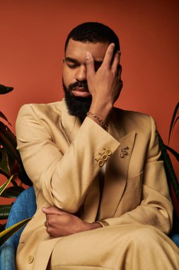 Yakışıklı bir adam yemyeşil bir alanda otururken bir anlık yansıma yapar..