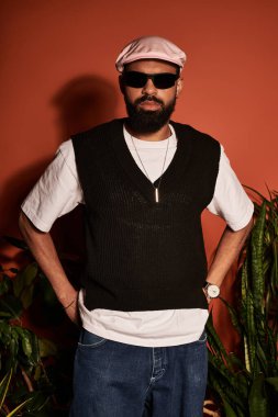 Tarz sahibi genç bir adam sıcak bir atmosferde moda kıyafetlerle yaz estetiğinden zevk alır..