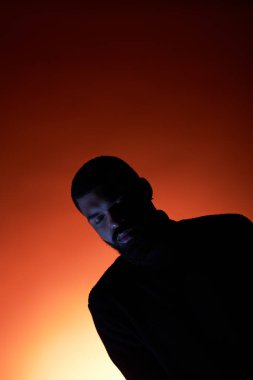 Yakışıklı bir genç yaz modasını sergilerken sıcak ve renkli atmosferin tadını çıkarıyor..