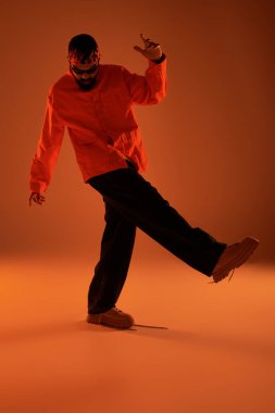 Tarz sahibi genç bir adam büyüleyici ışıkla etkileşime girerek yaz estetiğini sergiliyor..