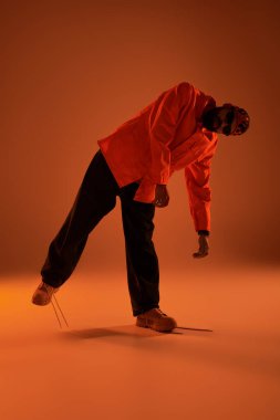 Genç bir adam yaz havası yayıyor. Sıcak bir ışıkla şık bir poz veriyor.