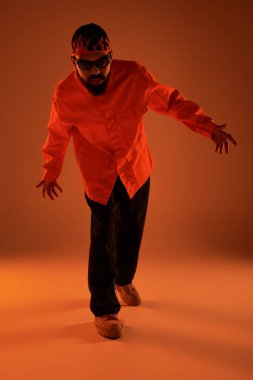 Genç adam canlı yaz kıyafetleriyle kasıla kasıla yürüyor, rahat bir cazibe yayıyor..