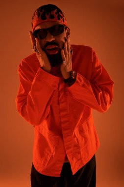 Şık bir genç adam coşkulu bir kıyafetle, yaz enerjisini ılık bir ışıkla ifade eder..