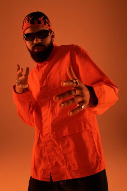 Çekici bir genç adam şık bir kıyafet ve şık aksesuarlar sergilerken yaz havasından zevk alır.