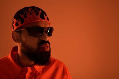 Genç adam yaz tarzını canlı renklerle ve sıcak ışıkta kendinden emin bir tavırla sergiliyor.