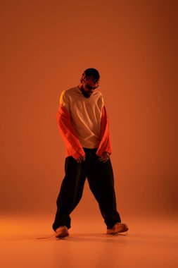 Titreşimli sıcak tonlar, yaz modasına uygun giyinmiş havalı bir gencin serin özgüvenini ön plana çıkarıyor..