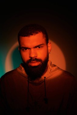 Sakallı genç bir adam, parlak bir yaz ayininde sıcak renklerde cazibe saçar..