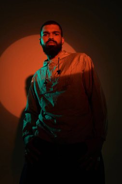 Çarpıcı bir yaz estetiğinde, yakışıklı genç bir adam parlak ışık altında moda sergiliyor..