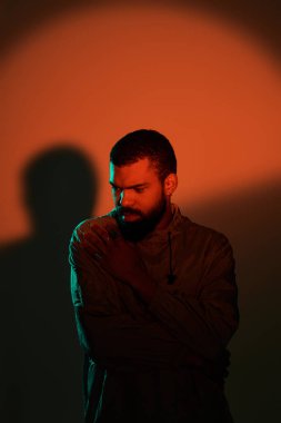 Genç bir adam, ılık ve canlı renklere karşı zahmetsiz yaz modasını sergiliyor.