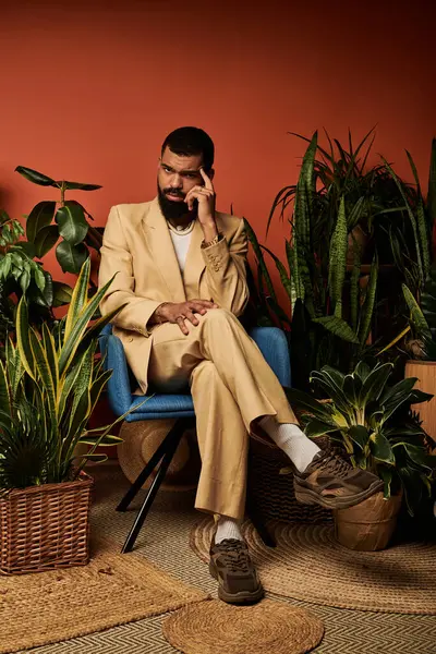 Şık bir genç adam canlı yeşillikler, coşkulu yaz cazibesi ve zarafeti arasında düşünceli bir şekilde oturur..