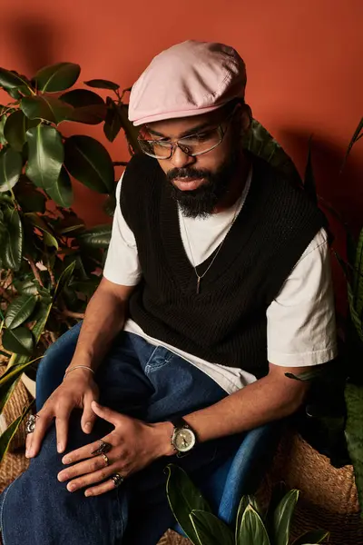 Şık bir genç adam rahat, bitki dolu bir yerde rahatlar, yaz havası yayar..