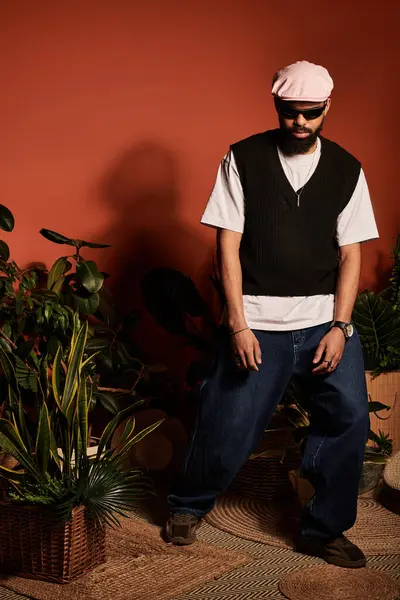 Şık bir genç adam yemyeşil bir ortamda rahat bir şekilde poz verir..