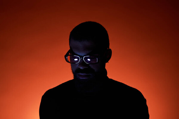 A young man with glasses showcases summer fashion while surrounded by warm colors.