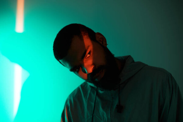 A stylish young man displays summer fashion, exuding cool confidence against a vibrant backdrop.