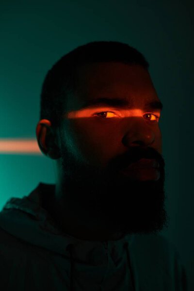 Молодой человек излучает летний шарм с завораживающим освещением, подчеркивающим его черты..