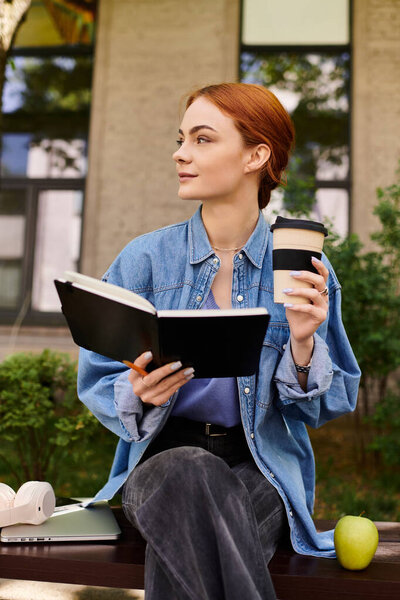 A red haired woman enjoys coffee and writes in her journal in nature.